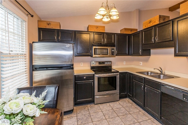 kitchen featuring sink, lofted ceiling, stainless steel appliances, and hanging light fixtures