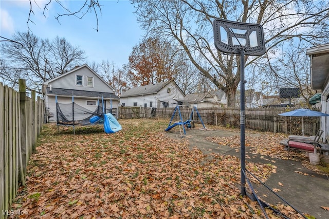 view of yard featuring a trampoline and a playground