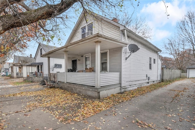 view of front facade featuring covered porch, a garage, and an outdoor structure