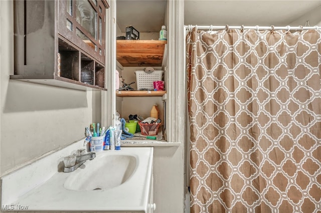 bathroom with a shower with shower curtain and sink