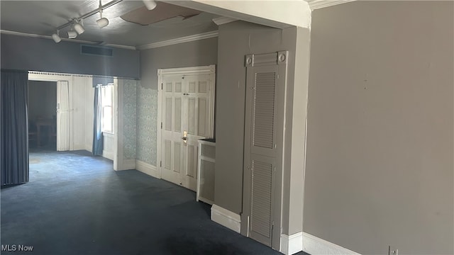 hallway with crown molding and rail lighting