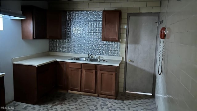 kitchen featuring light tile patterned floors, backsplash, and sink