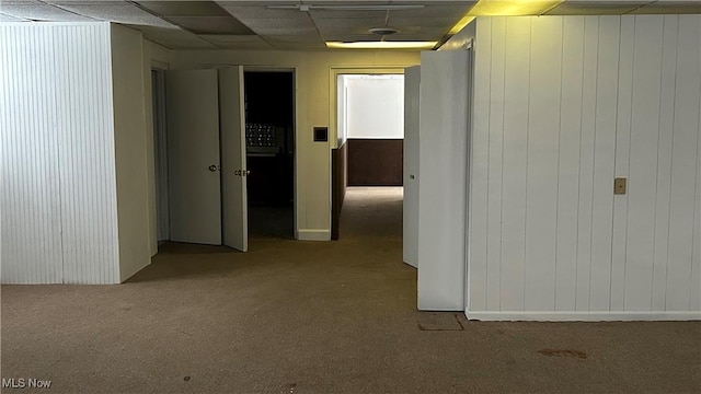 hall featuring a paneled ceiling and carpet