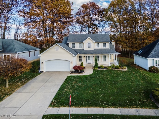 view of front of home with covered porch, a garage, and a front yard