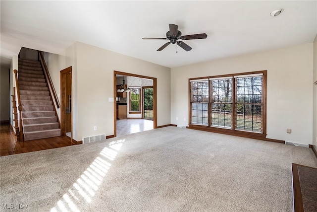 unfurnished living room with dark carpet and ceiling fan