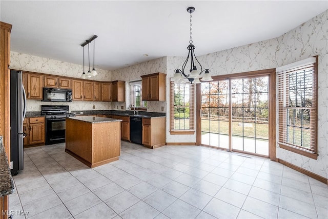 kitchen featuring a center island, decorative light fixtures, an inviting chandelier, and black appliances