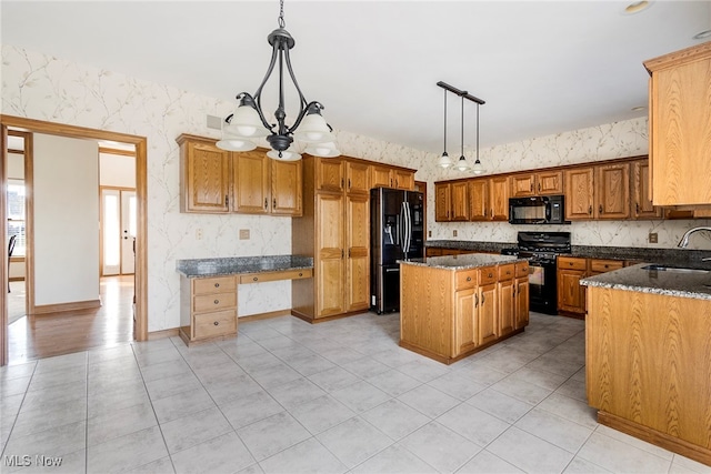 kitchen with a center island, hanging light fixtures, an inviting chandelier, dark stone counters, and black appliances