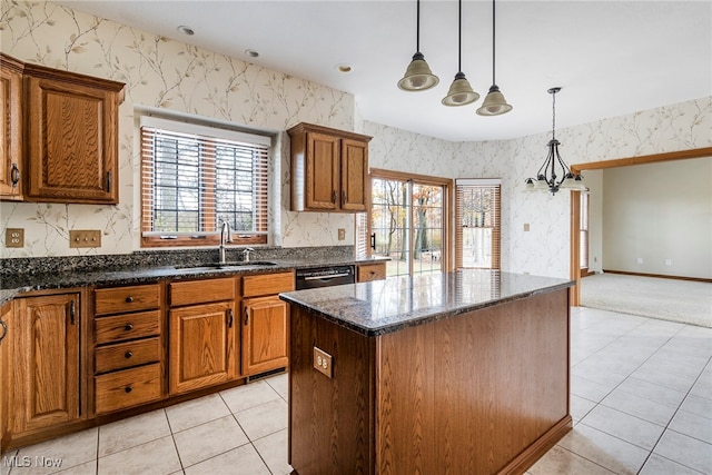 kitchen featuring pendant lighting, a center island, sink, dark stone countertops, and light tile patterned flooring