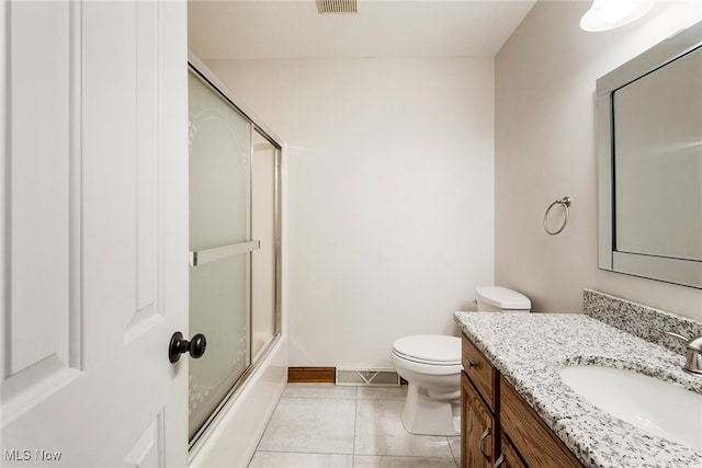 full bathroom featuring tile patterned flooring, combined bath / shower with glass door, toilet, and vanity