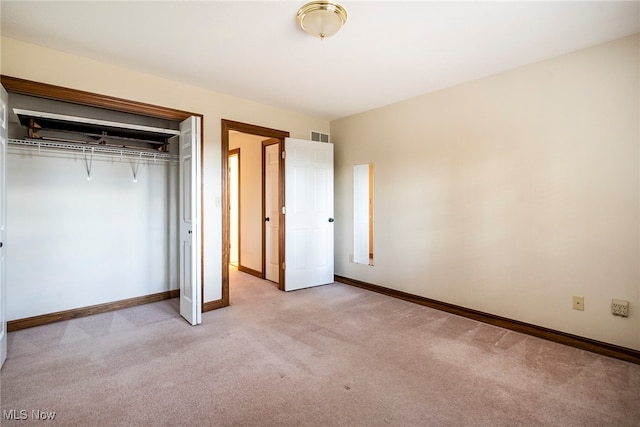 unfurnished bedroom with light colored carpet and a closet