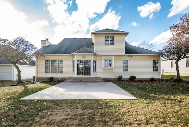 back of house with a lawn and a patio