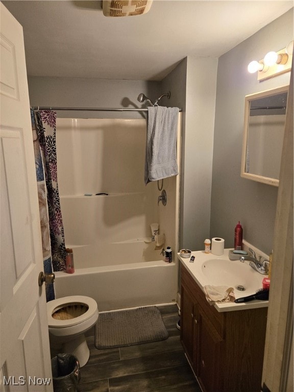 full bathroom with shower / tub combo, vanity, hardwood / wood-style flooring, and toilet