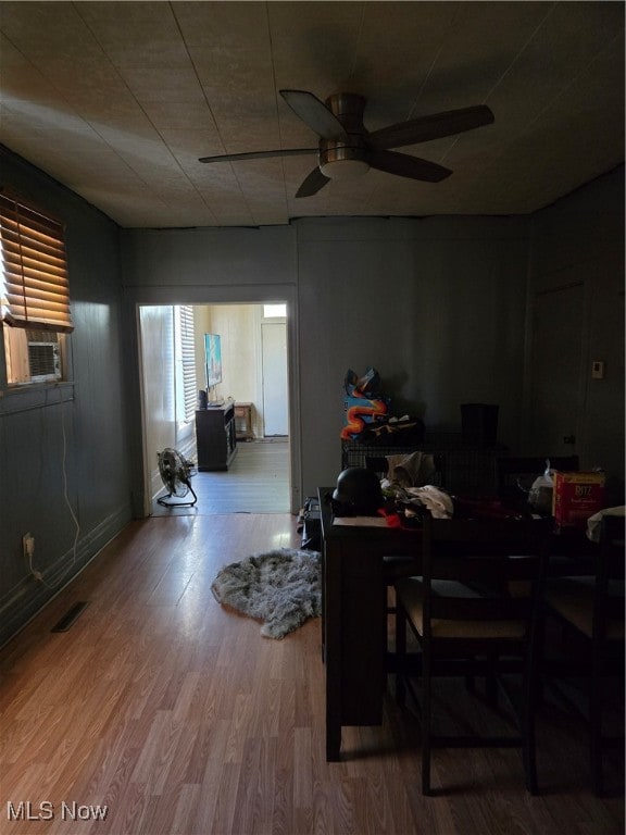 dining area featuring ceiling fan, cooling unit, and hardwood / wood-style flooring