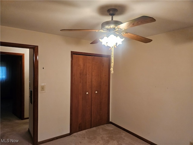 unfurnished bedroom featuring ceiling fan, a closet, and carpet floors