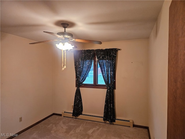 carpeted spare room with ceiling fan and a baseboard heating unit