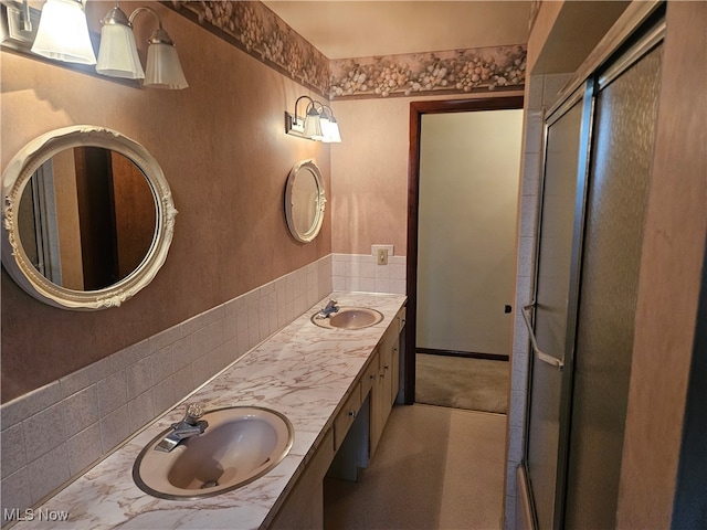 bathroom featuring a shower with door and vanity