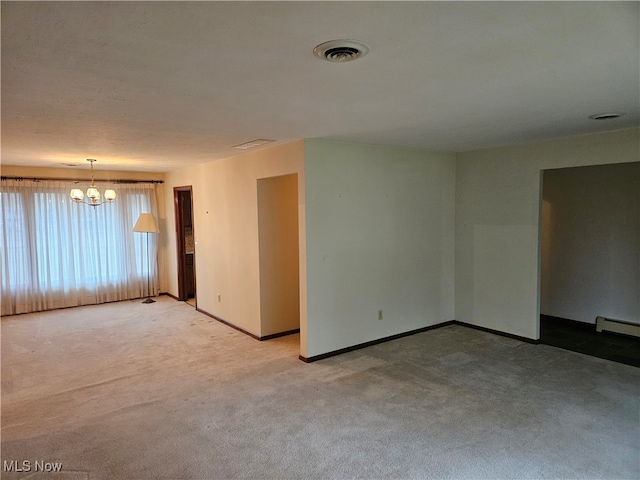 carpeted spare room featuring a chandelier and a baseboard heating unit