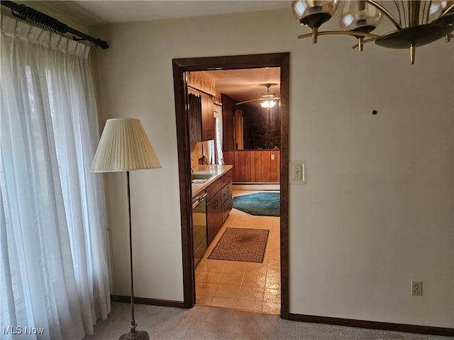 hallway featuring light tile patterned floors, a baseboard heating unit, and a notable chandelier