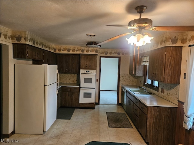 kitchen featuring dark brown cabinets, white appliances, a textured ceiling, ceiling fan, and sink