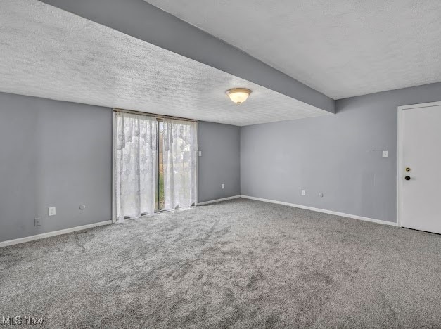 carpeted spare room with a textured ceiling