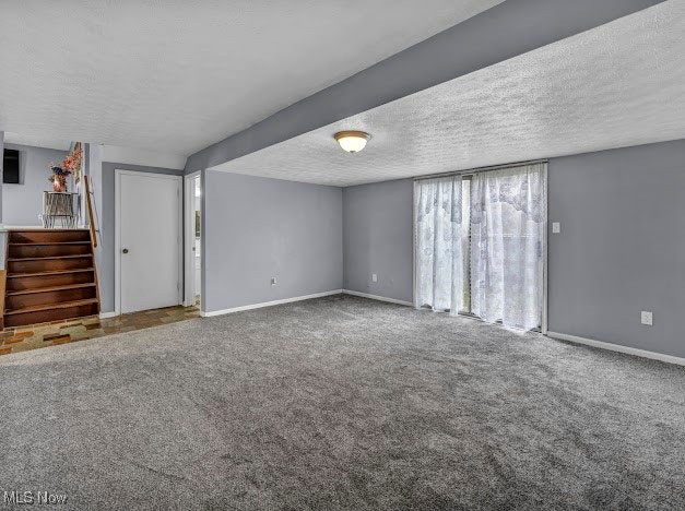 unfurnished living room with carpet and a textured ceiling