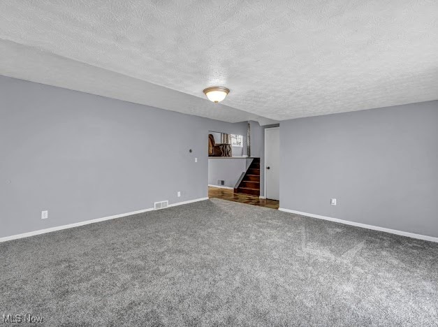 unfurnished living room with a textured ceiling and carpet floors