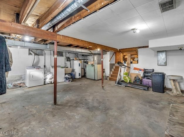 basement with washer / dryer, electric water heater, and heating unit