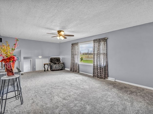 unfurnished room featuring carpet flooring, a textured ceiling, and ceiling fan