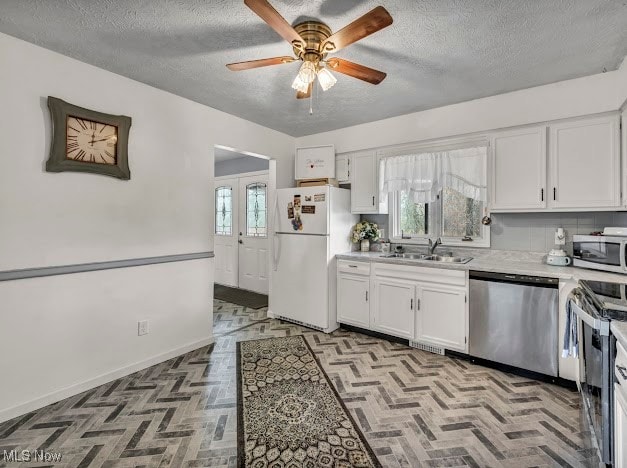 kitchen with plenty of natural light, white cabinetry, and appliances with stainless steel finishes