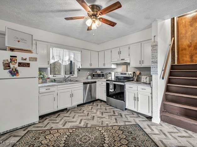 kitchen with white cabinetry, sink, ceiling fan, a textured ceiling, and appliances with stainless steel finishes