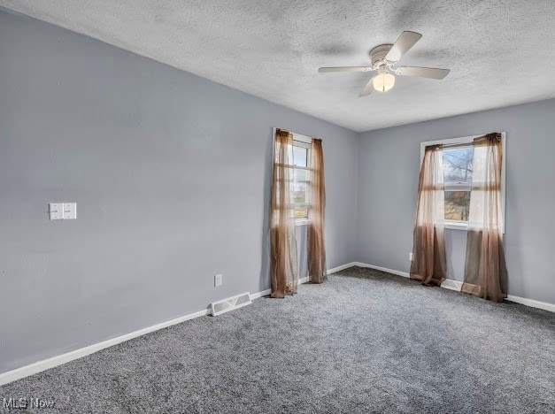 spare room with ceiling fan, carpet floors, and a textured ceiling