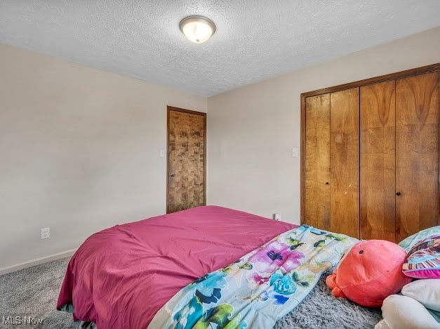 bedroom featuring a textured ceiling, carpet floors, and a closet