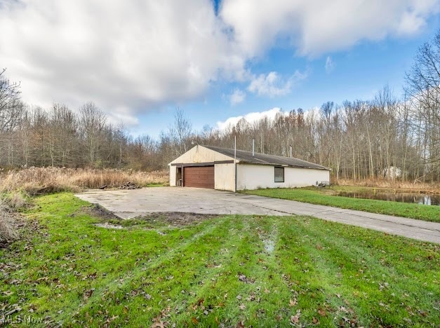 view of side of property featuring a lawn and a garage