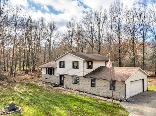 split level home with a front lawn and a garage