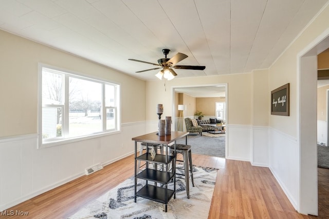 dining space with ceiling fan and light hardwood / wood-style flooring