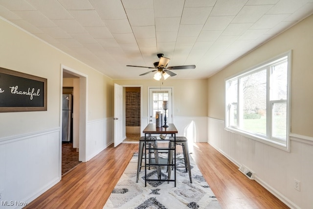 dining space with ceiling fan and light hardwood / wood-style flooring