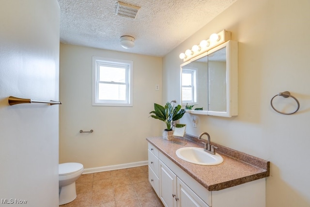 bathroom featuring vanity, a textured ceiling, and toilet