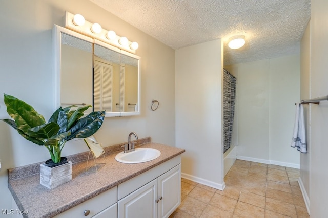 bathroom with vanity, tile patterned floors, a textured ceiling, and walk in shower