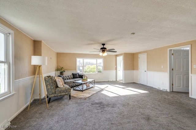 unfurnished living room featuring ceiling fan, carpet floors, and a textured ceiling