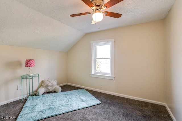 bonus room with vaulted ceiling, dark carpet, ceiling fan, and a textured ceiling