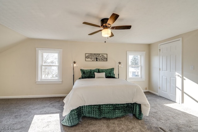 carpeted bedroom with multiple windows, vaulted ceiling, and ceiling fan