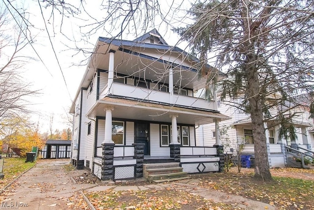 view of front facade featuring an outdoor structure, a balcony, and a porch