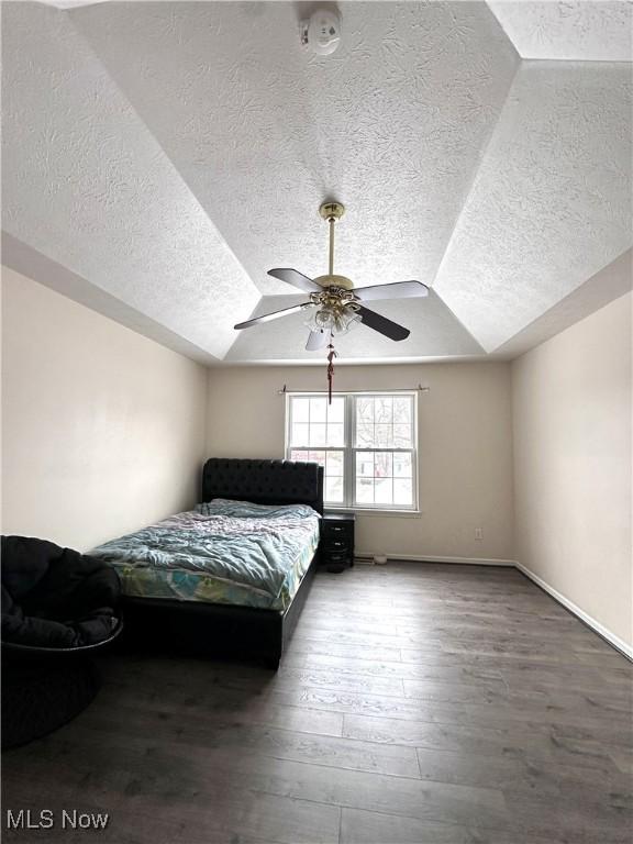 bedroom featuring a textured ceiling, dark hardwood / wood-style flooring, and ceiling fan