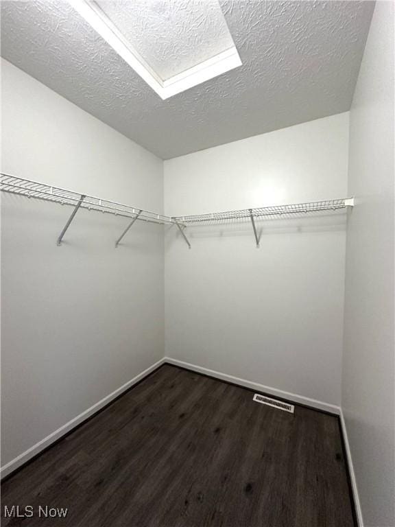 spacious closet with dark hardwood / wood-style floors