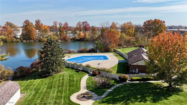 view of swimming pool with a lawn and a water view