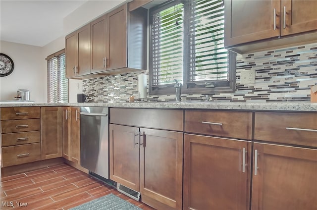 kitchen with tasteful backsplash, light stone counters, sink, and dark wood-type flooring