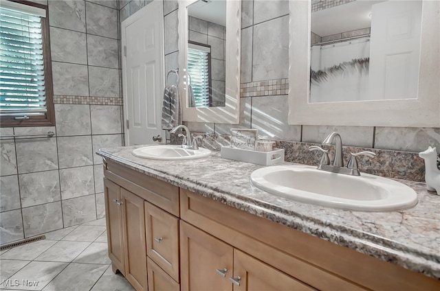 bathroom with tile patterned floors, vanity, tile walls, and walk in shower