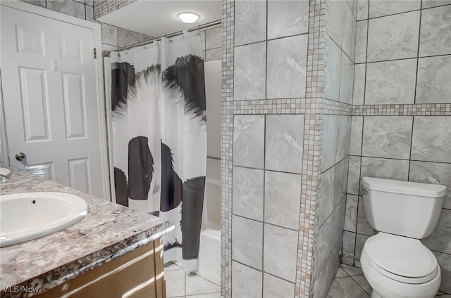 full bathroom with shower / tub combo, tile patterned flooring, vanity, and tile walls