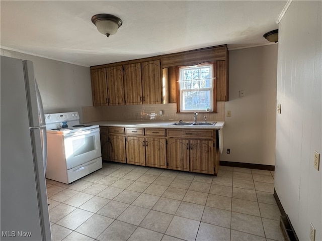 kitchen with decorative backsplash, sink, light tile patterned flooring, and white appliances