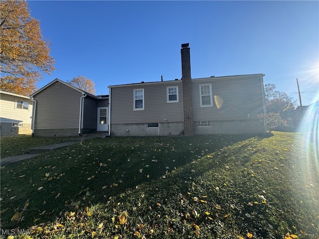 back of house featuring a lawn